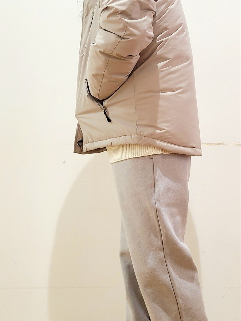 ホワイト系のニット/セーター、グレー系のスウェットパンツ、ベージュ系のダウンジャケット/コートを着用したメンズの冬コーディネートの9枚目の写真