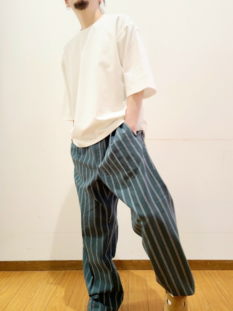 ホワイト系のTシャツ/カットソー、グリーン系のその他パンツ、ブラウン系のメガネを着用したメンズの夏コーディネートの7枚目の写真