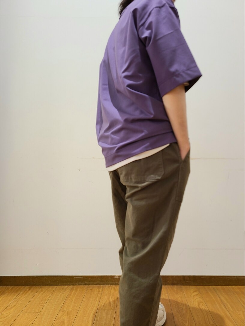 パープル系のTシャツ/カットソー、グリーン系のその他パンツ、ブラック系のキャップを着用したメンズの春コーディネートの6枚目の写真
