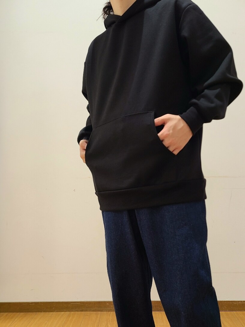 ブラック系のパーカー、ブルー系のデニムパンツを着用したメンズの秋コーディネートの5枚目の写真