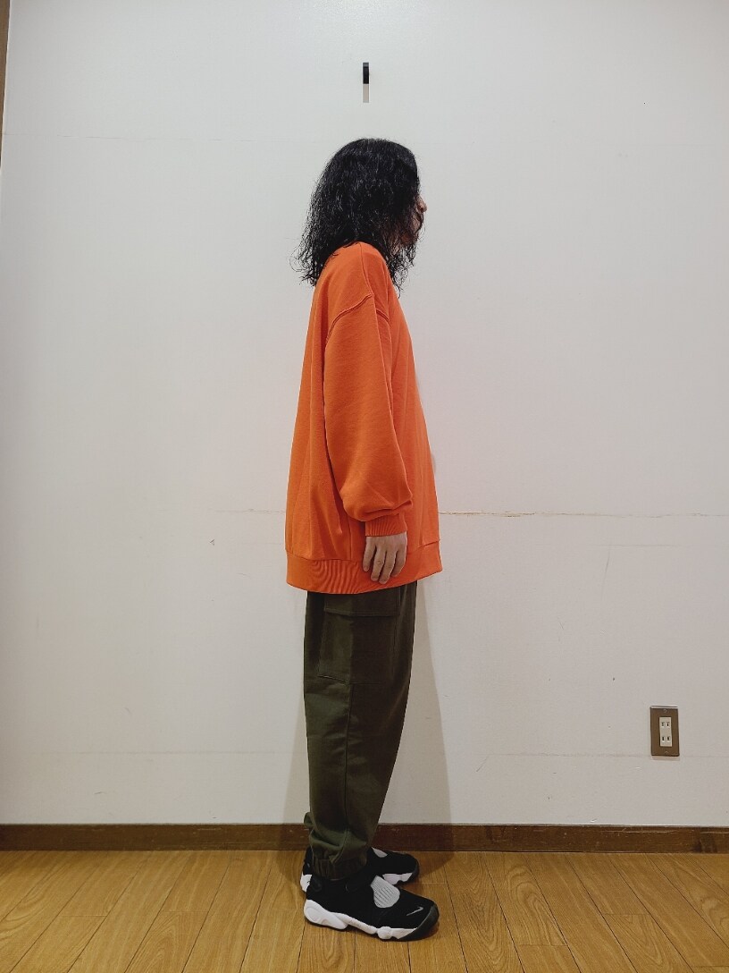 オレンジ系のスウェット、グリーン系のスウェットパンツを着用したメンズの秋コーディネートの3枚目の写真