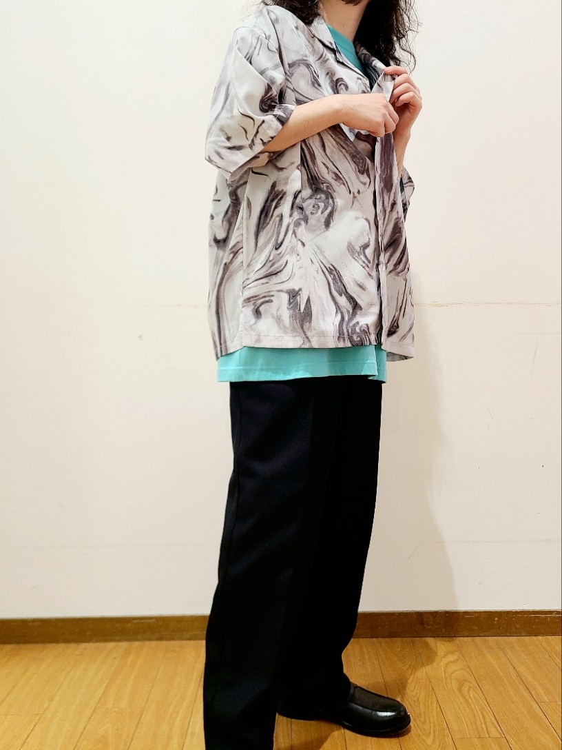 グリーン系のTシャツ/カットソー、ブラック系のスラックス、ホワイト系のシャツ/ブラウスを着用したメンズの夏コーディネートの8枚目の写真