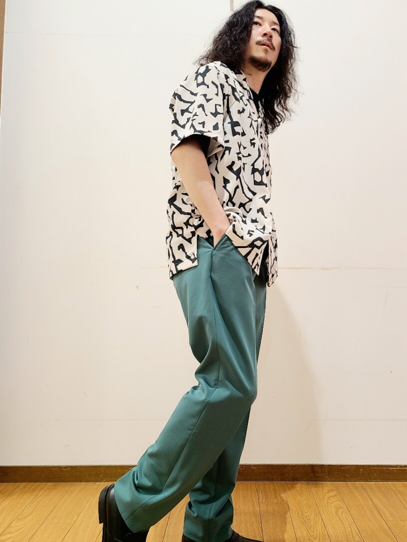 ホワイト系のシャツ/ブラウス、ブラック系のTシャツ/カットソー、グリーン系のスラックスを着用したメンズの春コーディネートの4枚目の写真