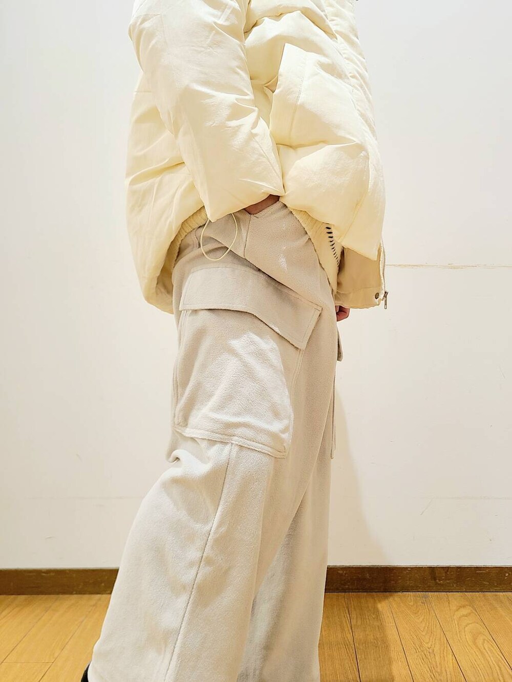 ホワイト系のダウンジャケット/コート、ホワイト系のニット/セーター、グレー系のその他パンツを着用したメンズの冬コーディネートの8枚目の写真