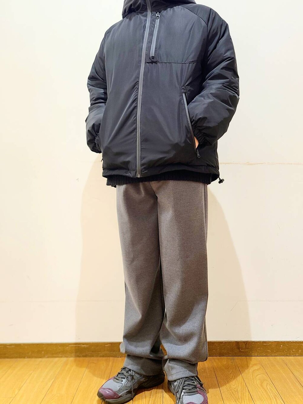 グレー系のその他パンツ、ブラック系のニット/セーター、ブラック系のダウンジャケット/コートを着用したメンズの冬コーディネートの6枚目の写真