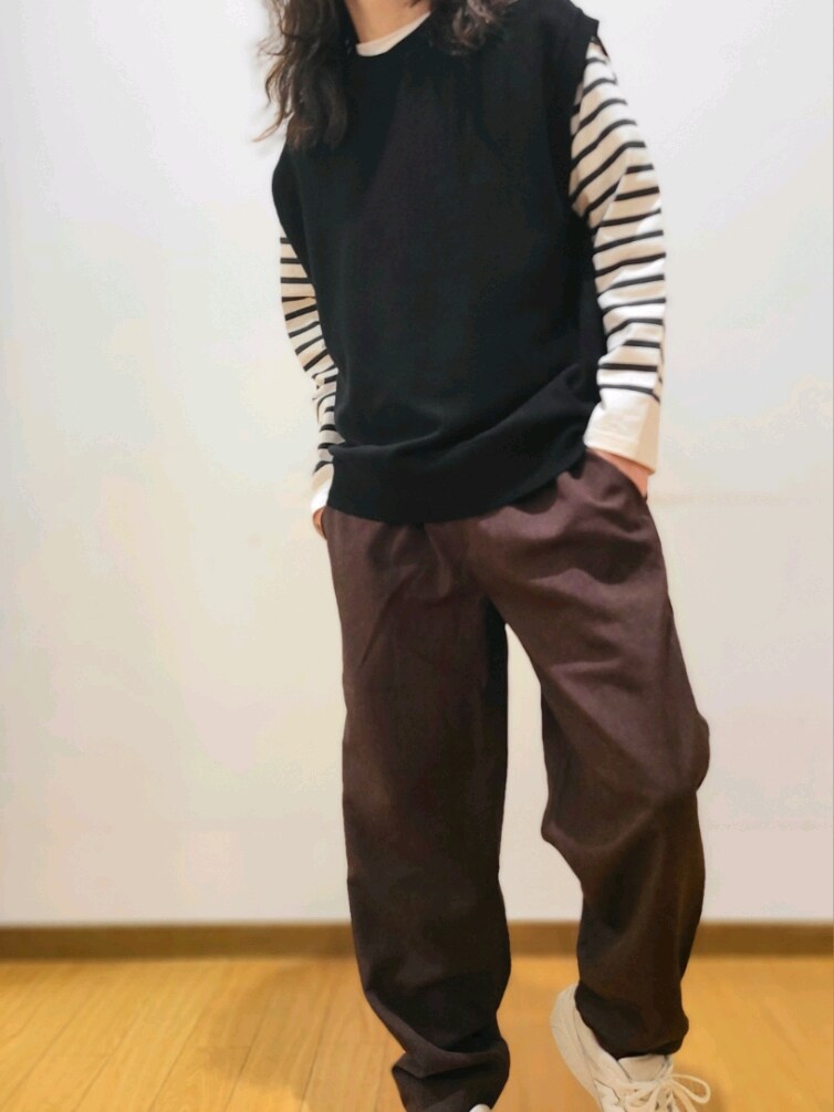 ブラック系のベスト、ブラック系のTシャツ/カットソー、ブラウン系のその他パンツを着用したメンズの春コーディネートの4枚目の写真