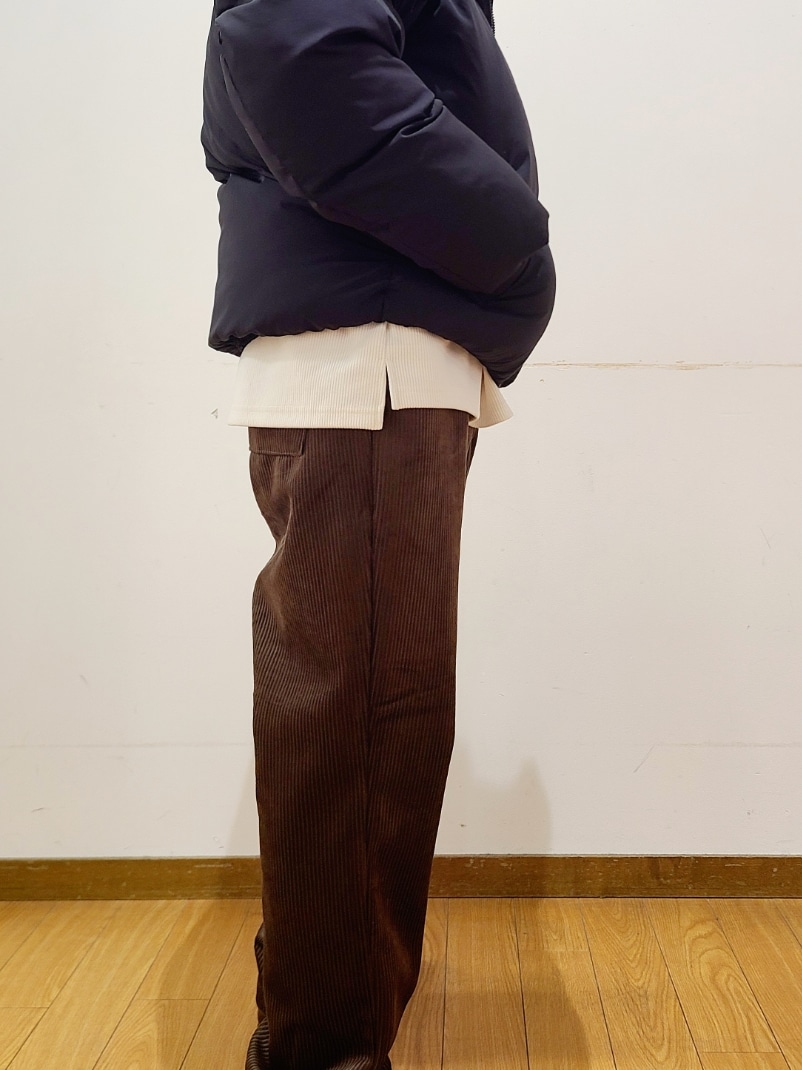 ブラック系のダウンジャケット/コート、ホワイト系のTシャツ/カットソー、ブラウン系のその他パンツを着用したメンズの冬コーディネートの4枚目の写真