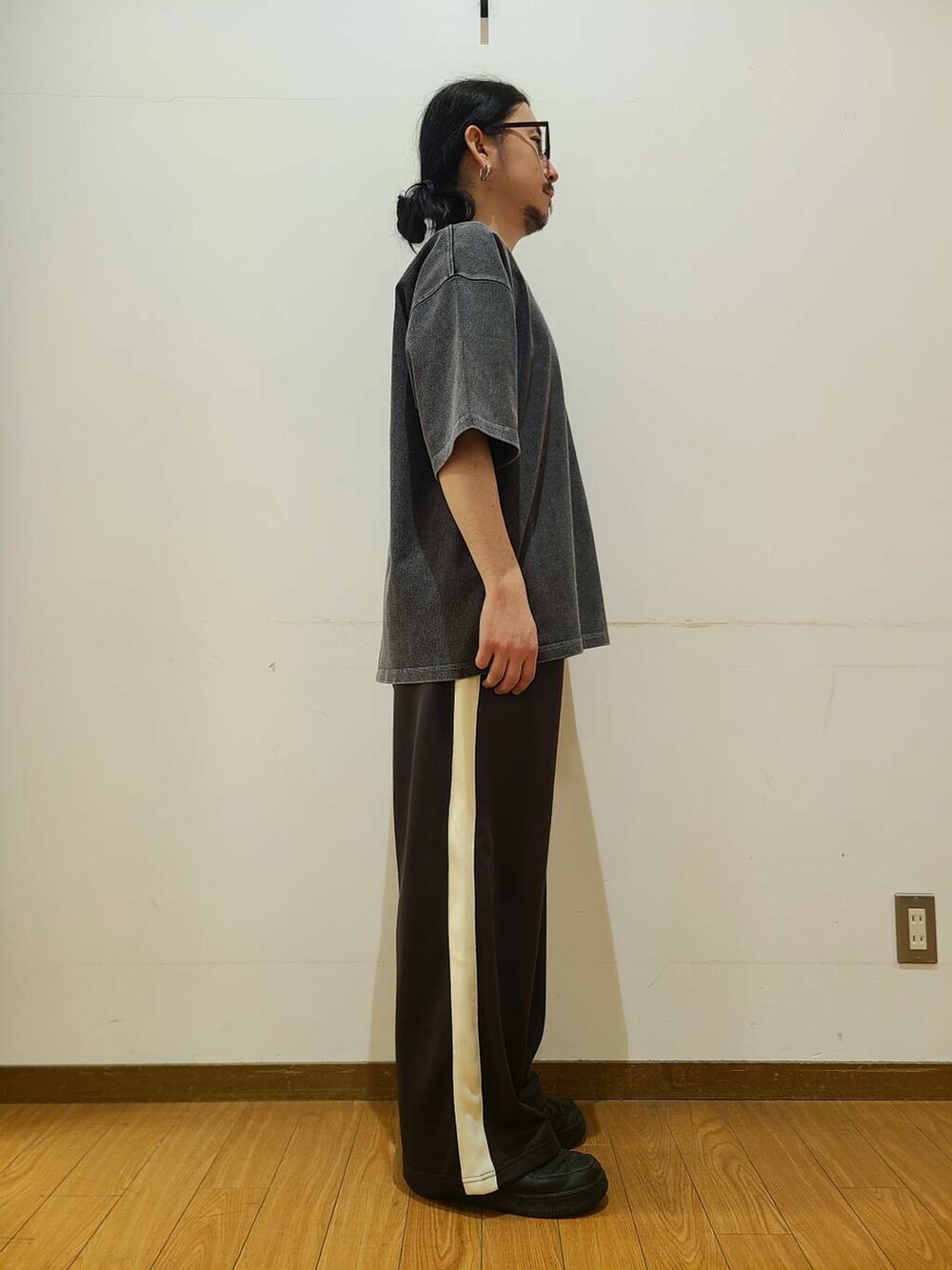 ブラウン系のその他パンツ、ブラック系のTシャツ/カットソー、グリーン系のメガネを着用したメンズの春コーディネートの2枚目の写真