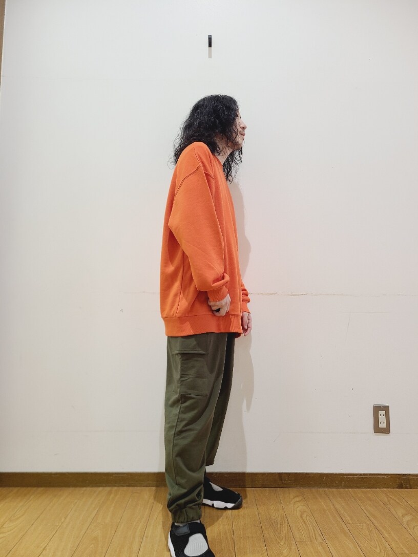 オレンジ系のスウェット、グリーン系のスウェットパンツを着用したメンズの秋コーディネートの8枚目の写真