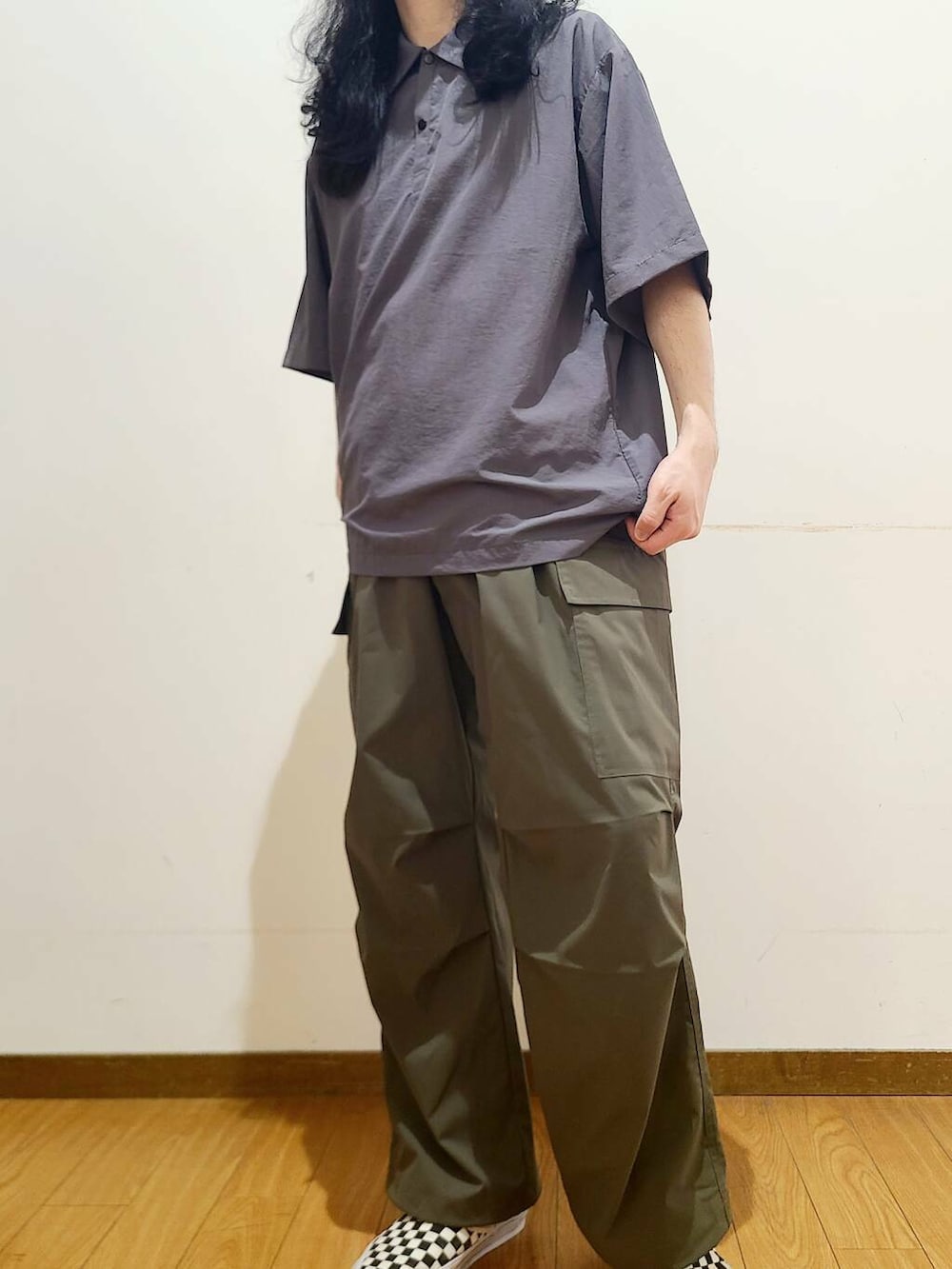 ブラック系のスニーカー、グリーン系のその他パンツ、グレー系のポロシャツを着用したメンズの春コーディネートの6枚目の写真