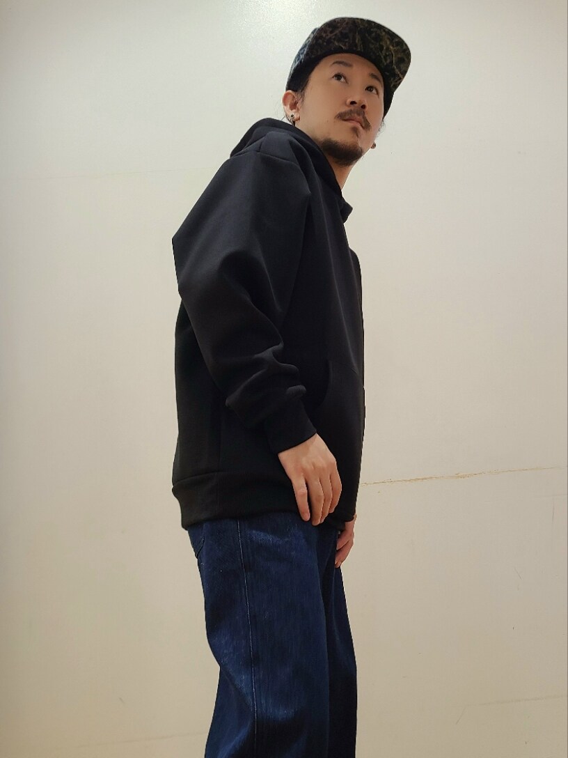 ブラック系のパーカー、ブルー系のデニムパンツを着用したメンズの秋コーディネートの4枚目の写真
