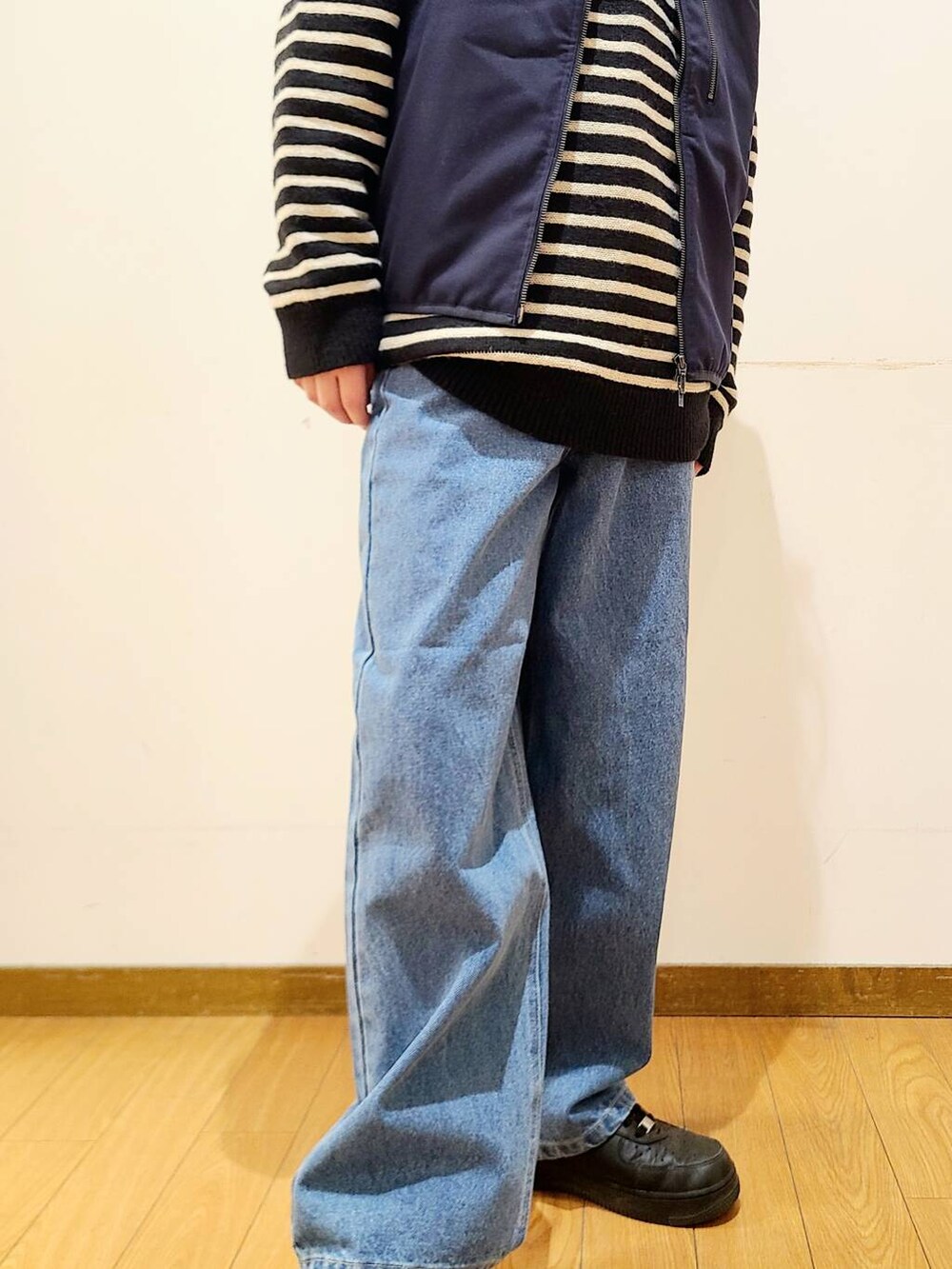 ブルー系のダウンベスト、ブルー系のデニムパンツ、ブラック系のニット/セーターを着用したメンズの冬コーディネートの7枚目の写真