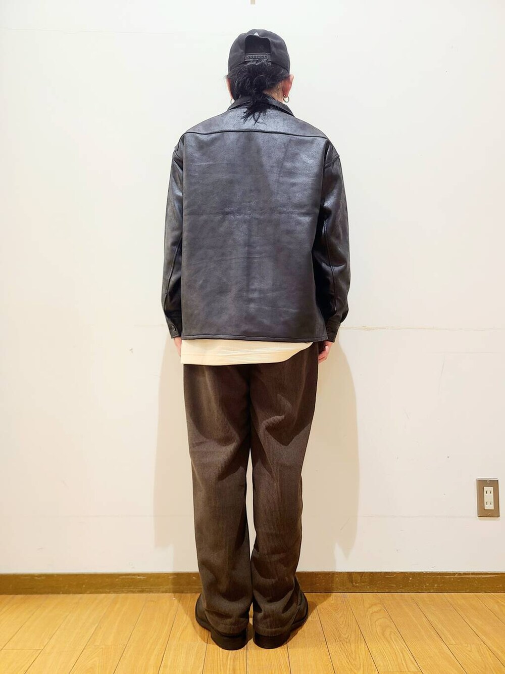 ブラック系のブルゾン、ブラウン系のその他パンツ、ホワイト系のTシャツ/カットソーを着用したメンズの冬コーディネートの3枚目の写真