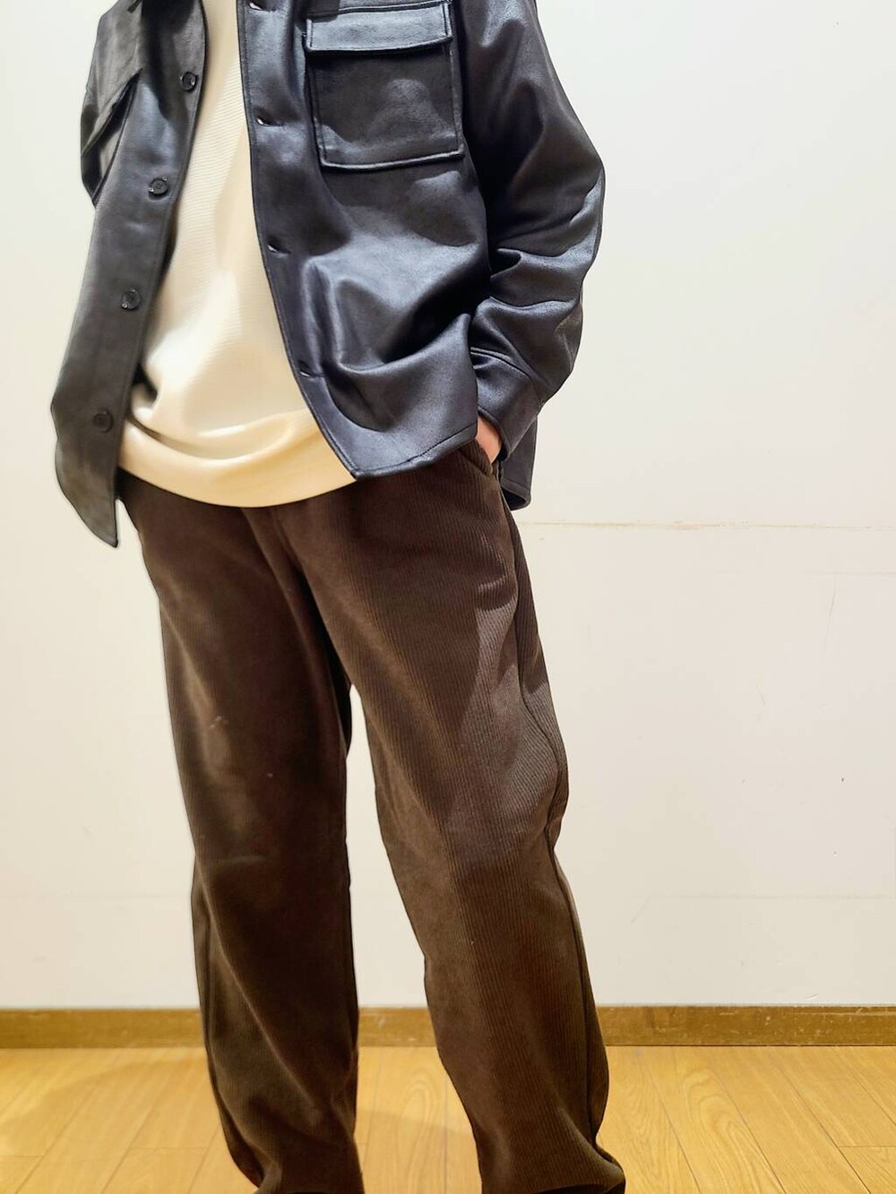 ブラック系のブルゾン、ブラウン系のその他パンツ、ホワイト系のTシャツ/カットソーを着用したメンズの冬コーディネートの7枚目の写真