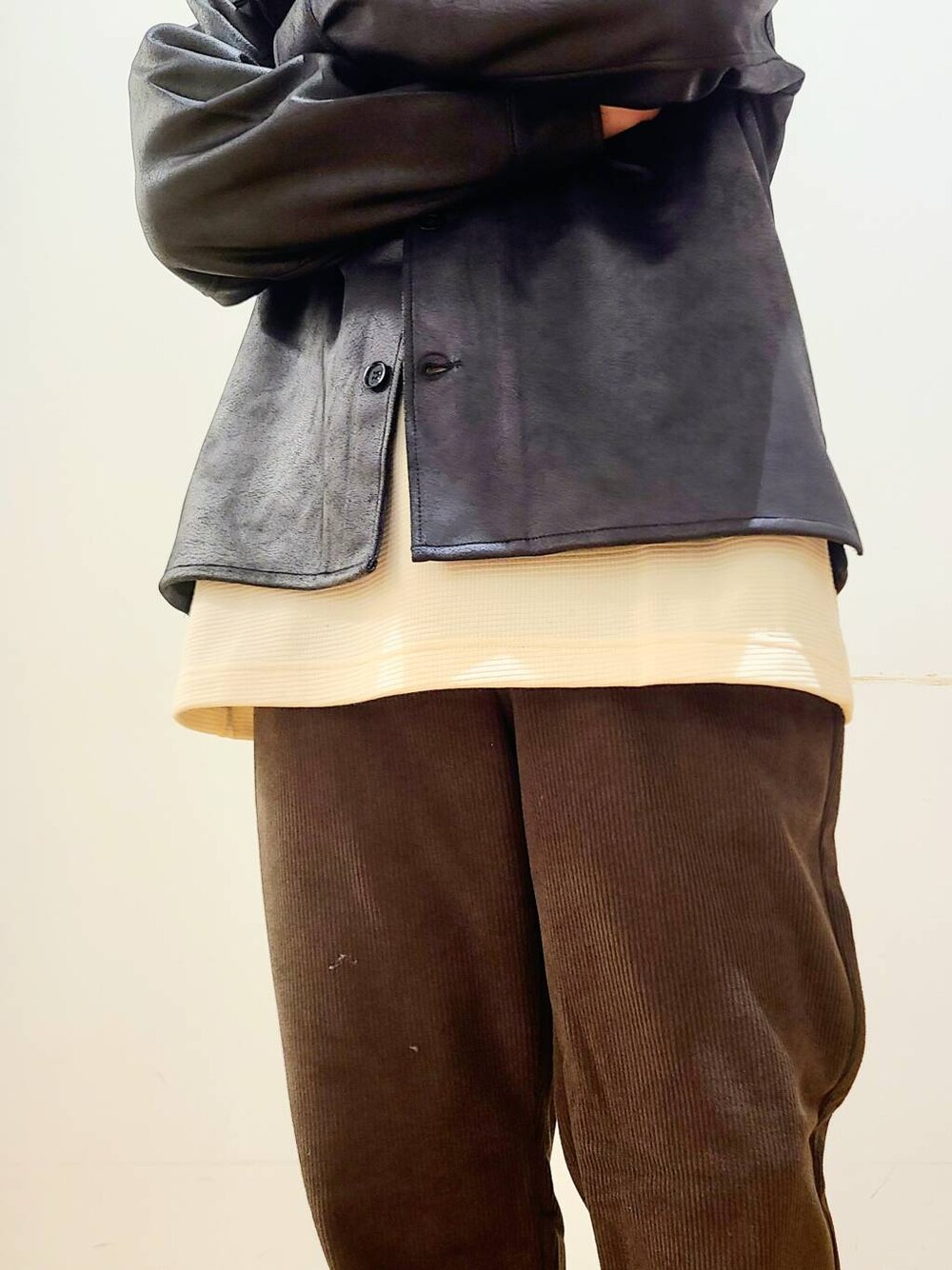 ブラック系のブルゾン、ブラウン系のその他パンツ、ホワイト系のTシャツ/カットソーを着用したメンズの冬コーディネートの5枚目の写真