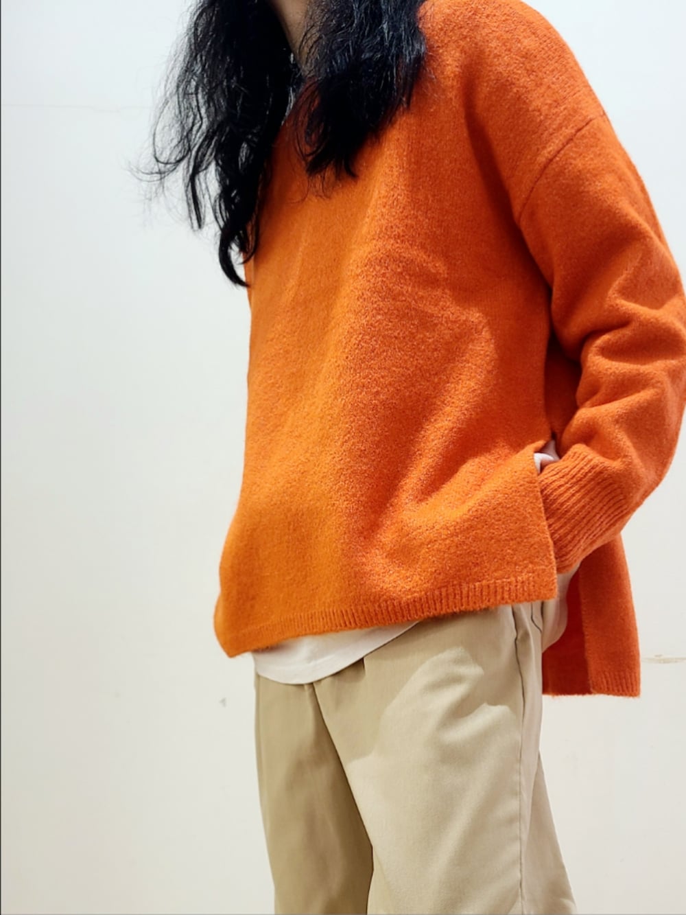 ベージュ系のその他パンツ、オレンジ系のニット/セーターを着用したメンズの冬コーディネートの6枚目の写真