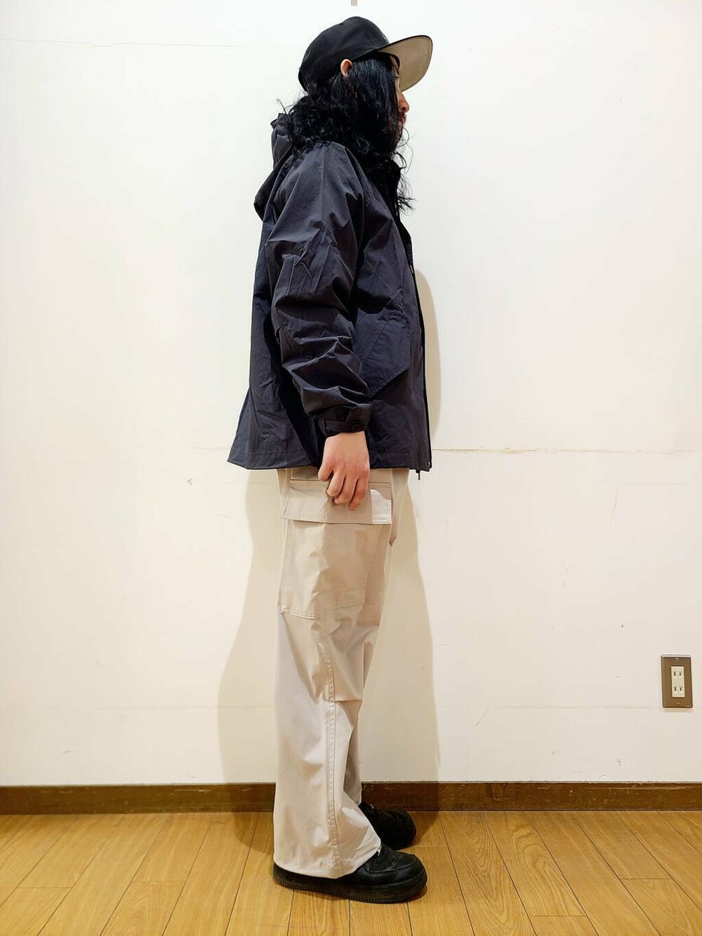 ブラック系のマウンテンパーカー、ホワイト系のその他パンツ、グレー系のTシャツ/カットソーを着用したメンズの冬コーディネートの2枚目の写真