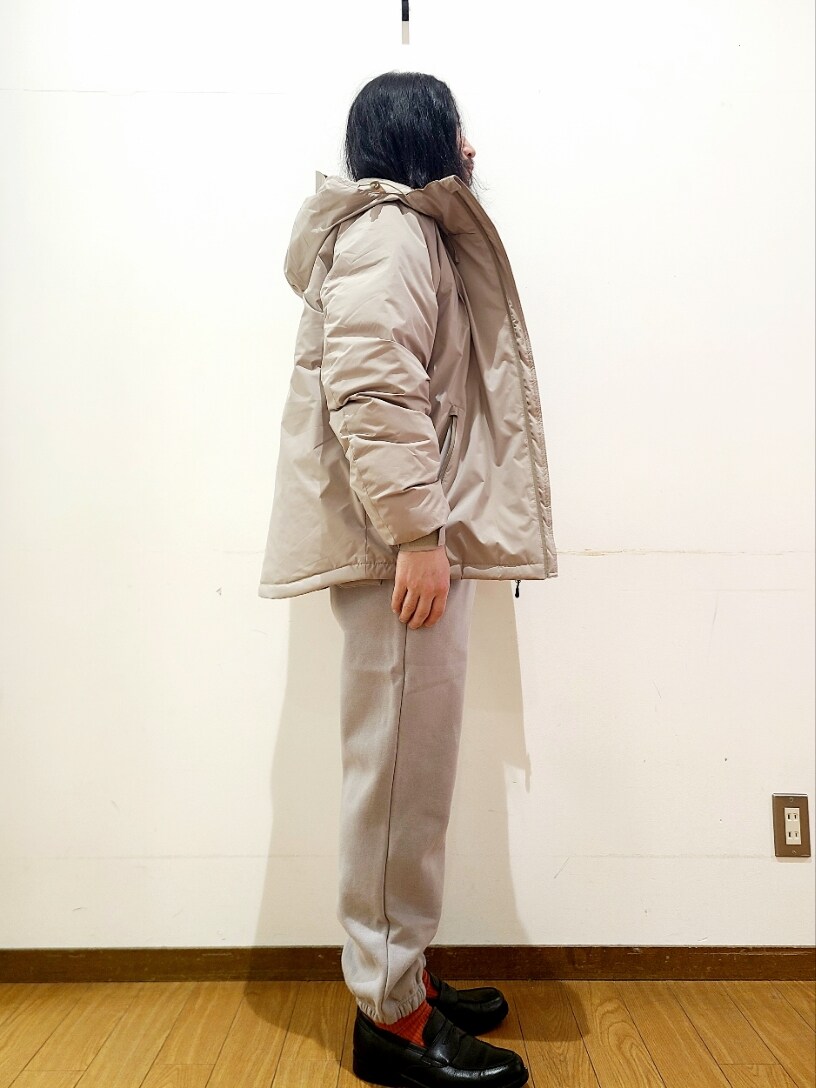 ホワイト系のニット/セーター、グレー系のスウェットパンツ、ベージュ系のダウンジャケット/コートを着用したメンズの冬コーディネートの2枚目の写真