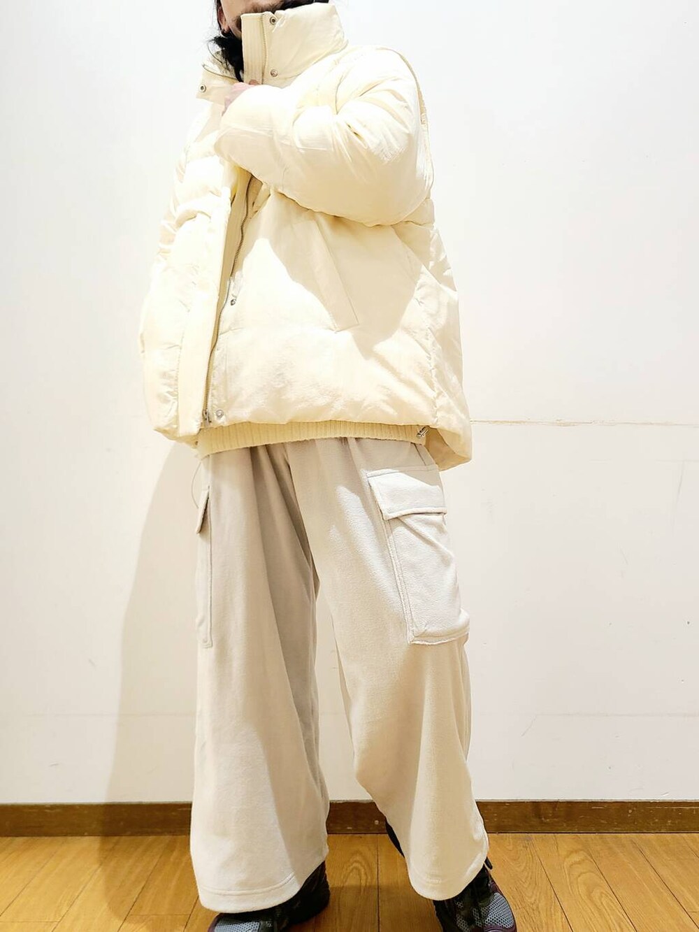 ホワイト系のダウンジャケット/コート、ホワイト系のニット/セーター、グレー系のその他パンツを着用したメンズの冬コーディネートの6枚目の写真