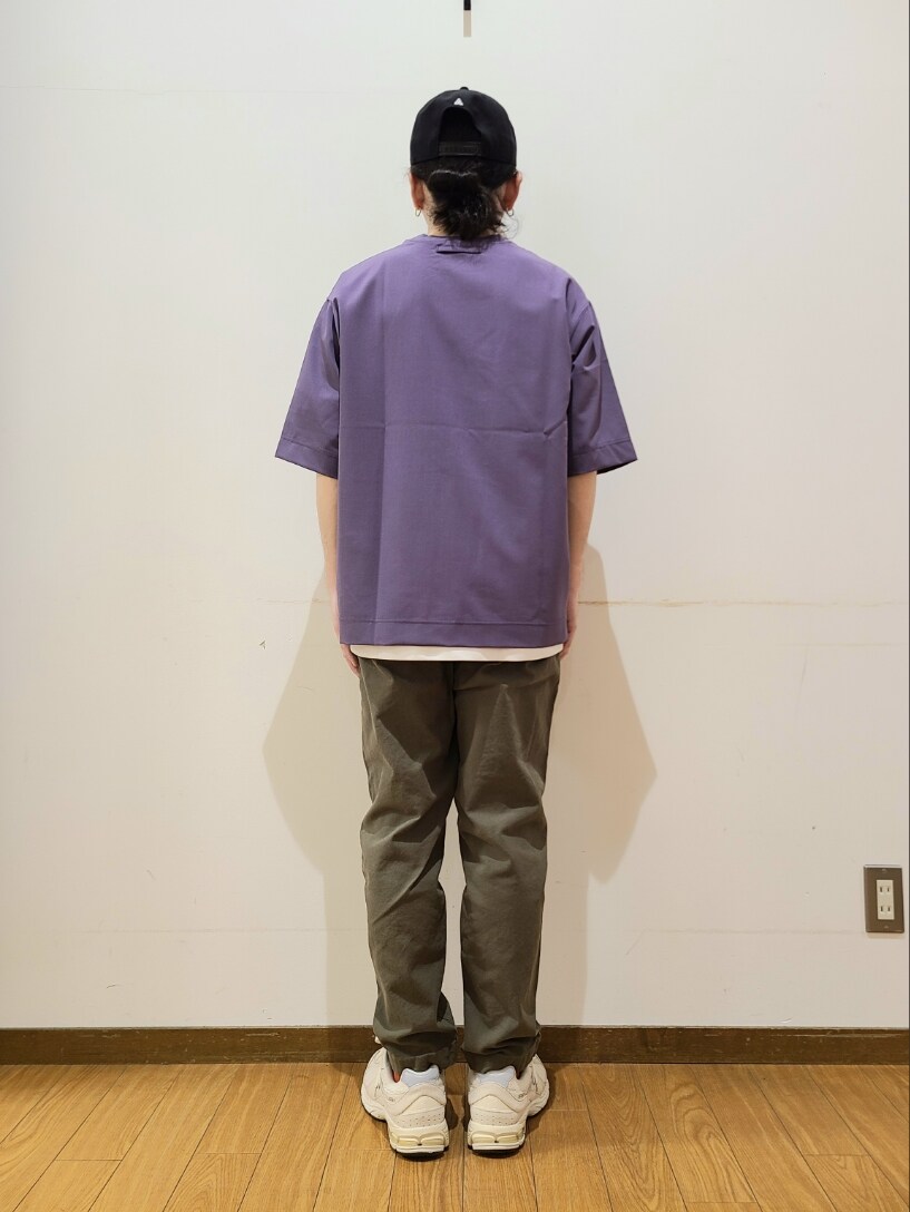 パープル系のTシャツ/カットソー、グリーン系のその他パンツ、ブラック系のキャップを着用したメンズの春コーディネートの3枚目の写真