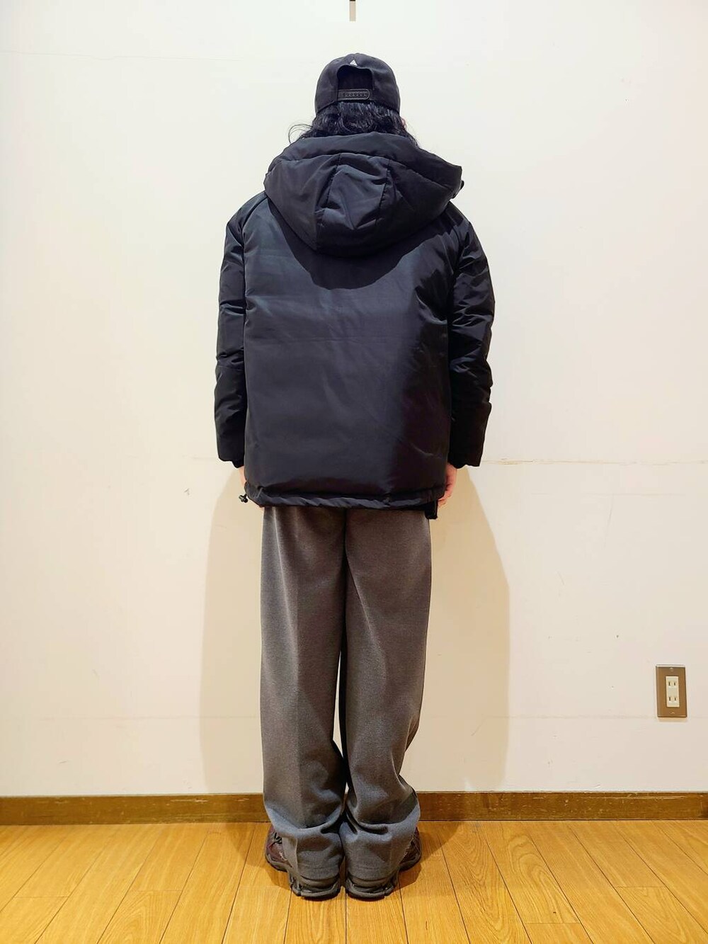 グレー系のその他パンツ、ブラック系のニット/セーター、ブラック系のダウンジャケット/コートを着用したメンズの冬コーディネートの3枚目の写真