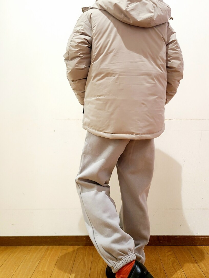 ホワイト系のニット/セーター、グレー系のスウェットパンツ、ベージュ系のダウンジャケット/コートを着用したメンズの冬コーディネートの6枚目の写真