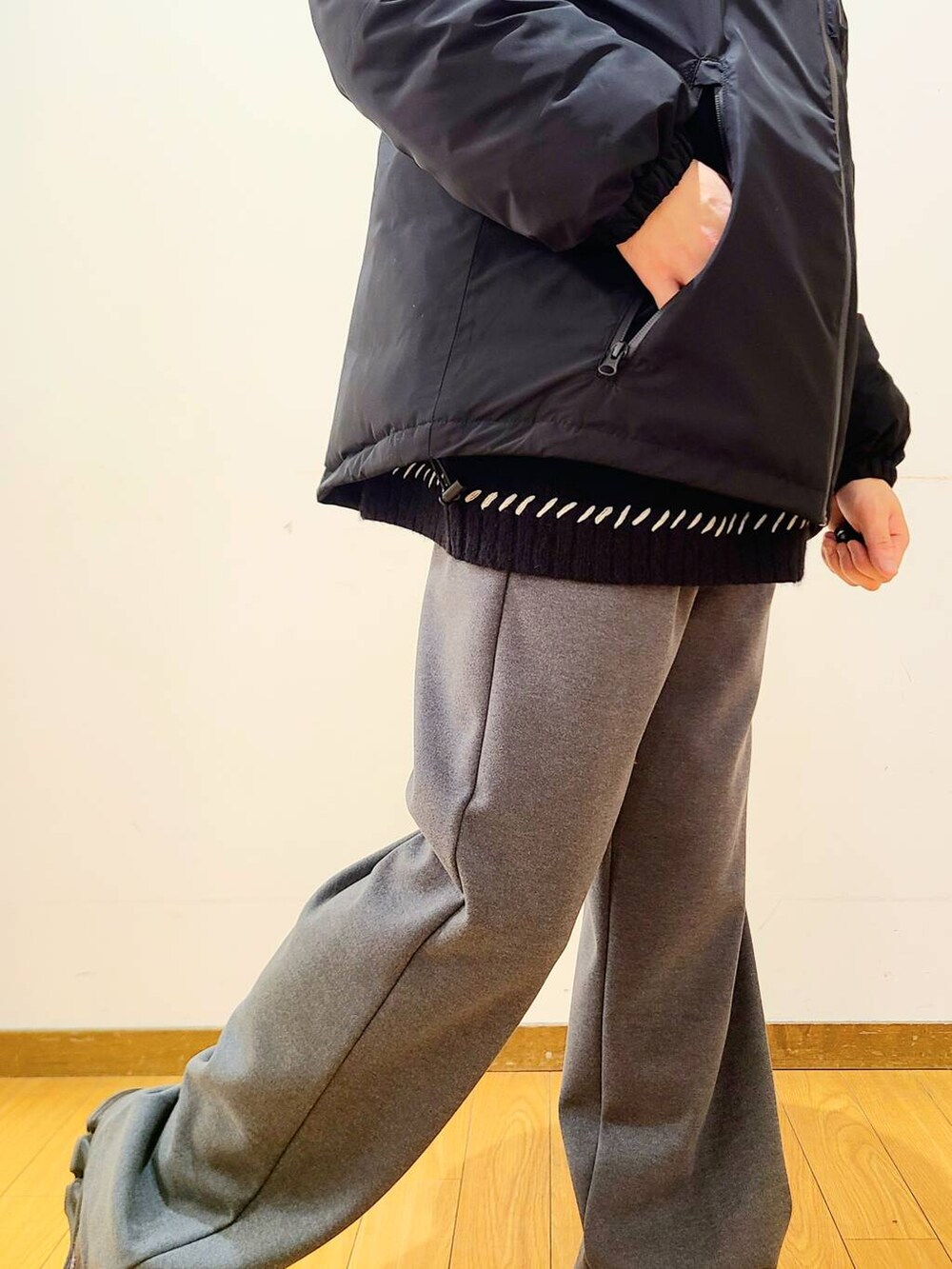 グレー系のその他パンツ、ブラック系のニット/セーター、ブラック系のダウンジャケット/コートを着用したメンズの冬コーディネートの7枚目の写真