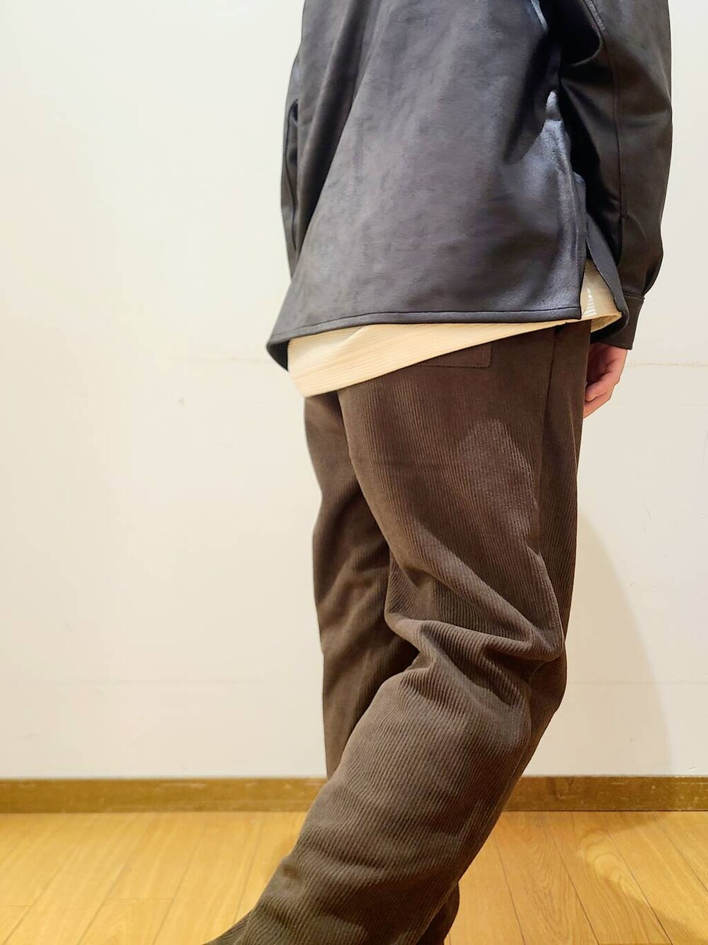ブラック系のブルゾン、ブラウン系のその他パンツ、ホワイト系のTシャツ/カットソーを着用したメンズの冬コーディネートの8枚目の写真