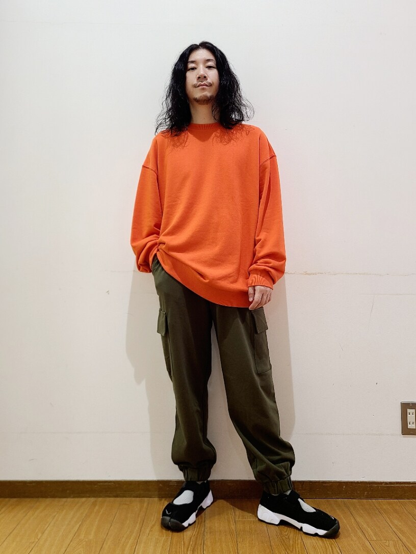オレンジ系のスウェット、グリーン系のスウェットパンツを着用したメンズの秋コーディネートの2枚目の写真