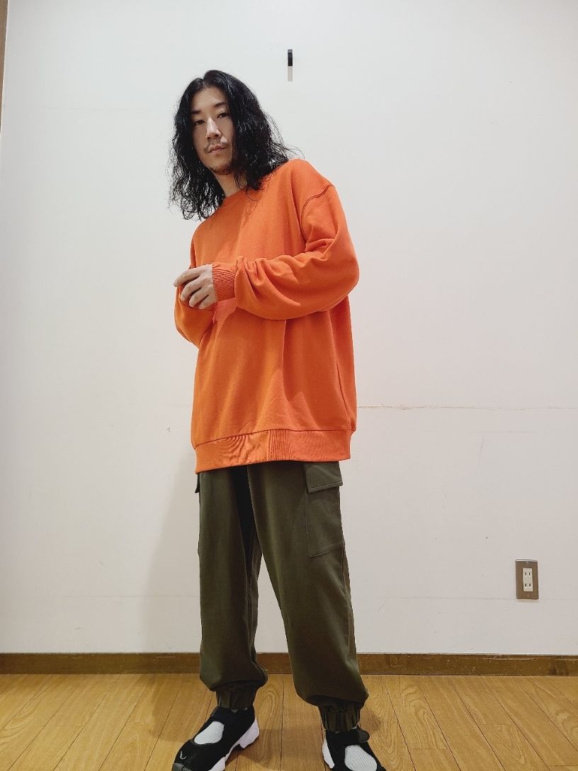 オレンジ系のスウェット、グリーン系のスウェットパンツを着用したメンズの秋コーディネートの5枚目の写真