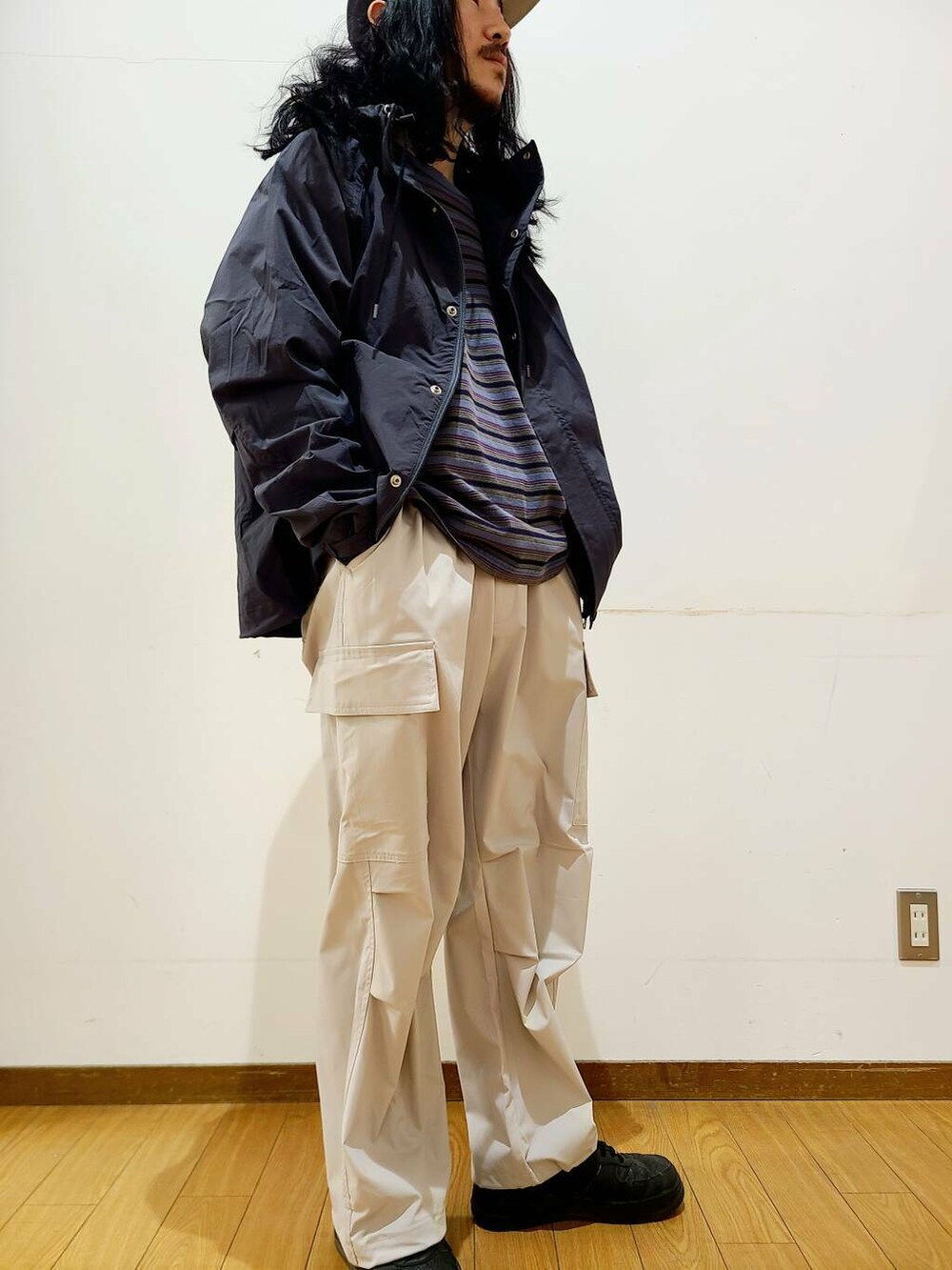 ブラック系のマウンテンパーカー、ホワイト系のその他パンツ、グレー系のTシャツ/カットソーを着用したメンズの冬コーディネートの5枚目の写真