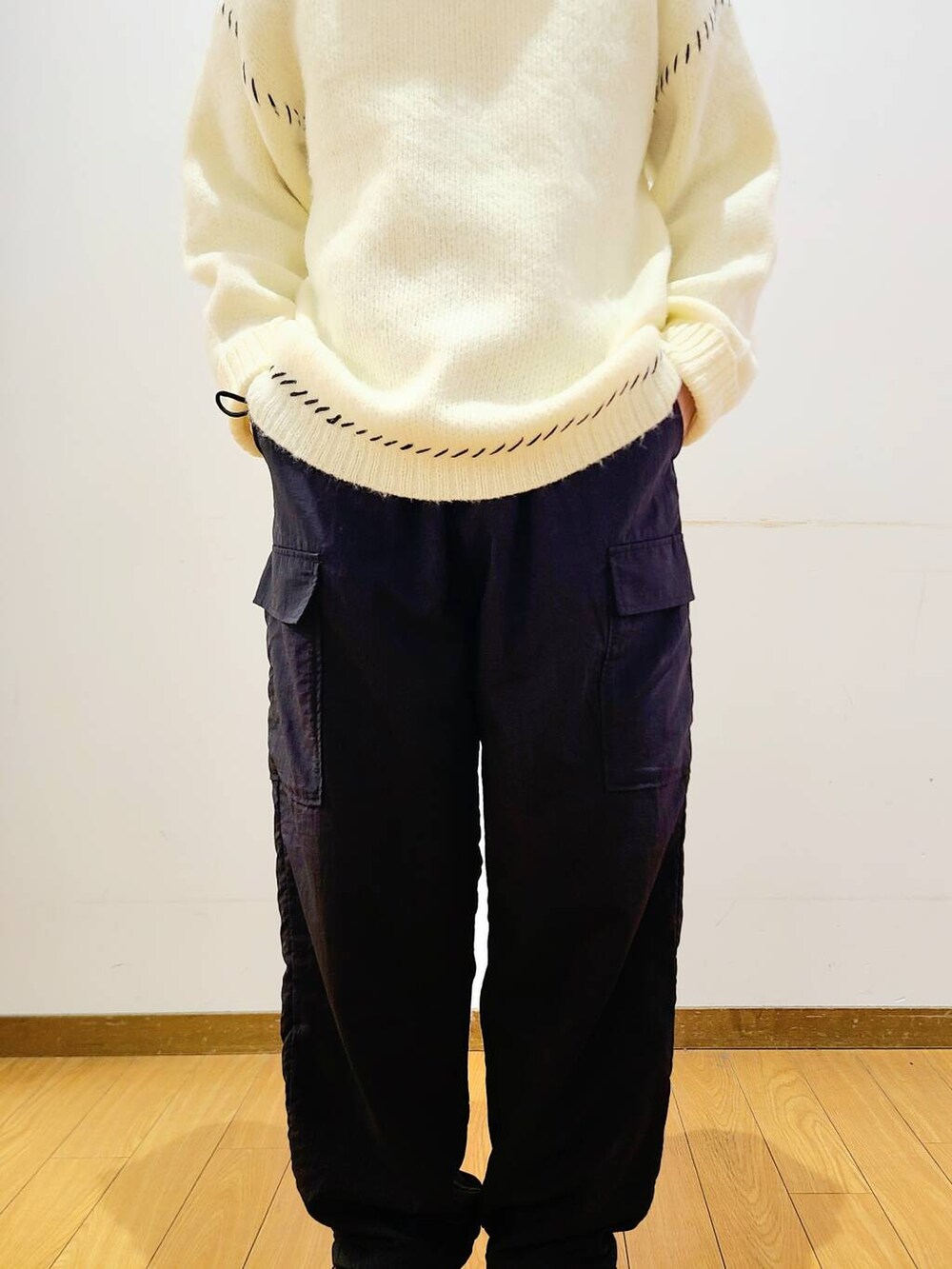 ブラック系のその他パンツ、ホワイト系のニット/セーターを着用したメンズの冬コーディネートの6枚目の写真