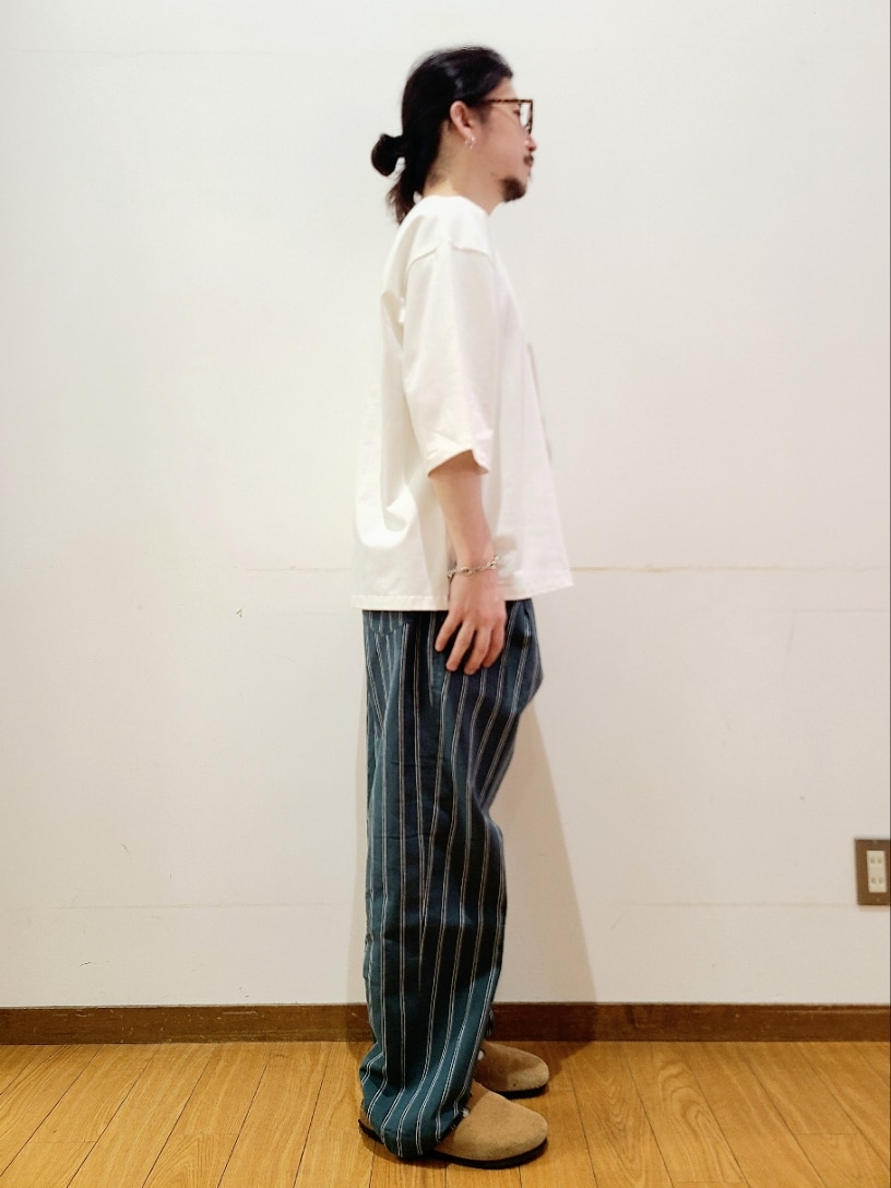 ホワイト系のTシャツ/カットソー、グリーン系のその他パンツ、ブラウン系のメガネを着用したメンズの夏コーディネートの2枚目の写真