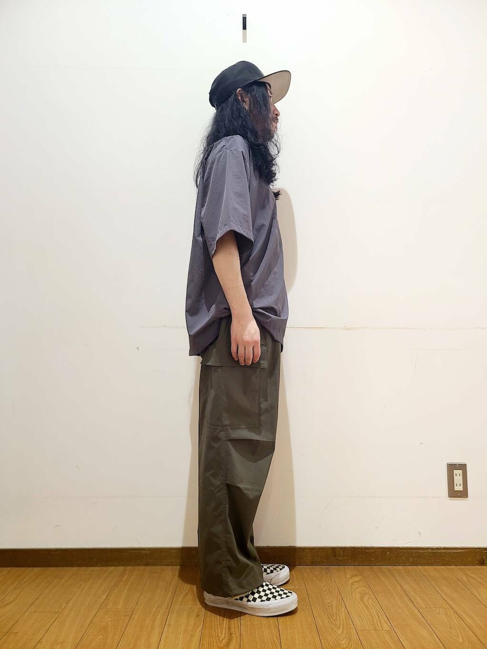 ブラック系のスニーカー、グリーン系のその他パンツ、グレー系のポロシャツを着用したメンズの春コーディネートの2枚目の写真