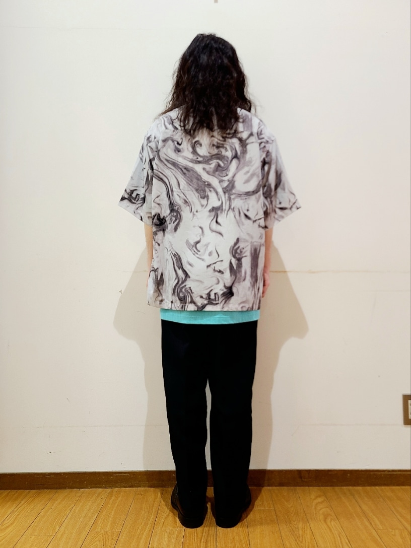 グリーン系のTシャツ/カットソー、ブラック系のスラックス、ホワイト系のシャツ/ブラウスを着用したメンズの夏コーディネートの3枚目の写真