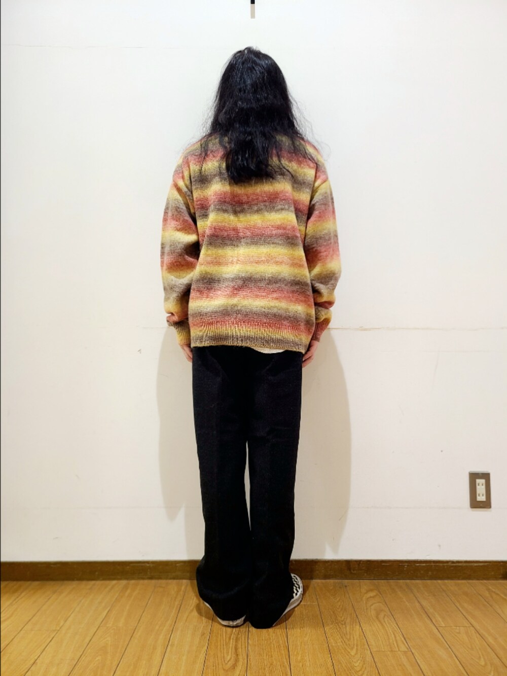 ブラック系のスニーカー、レッド系のニット/セーター、ブラック系のその他パンツを着用したメンズの秋コーディネートの4枚目の写真