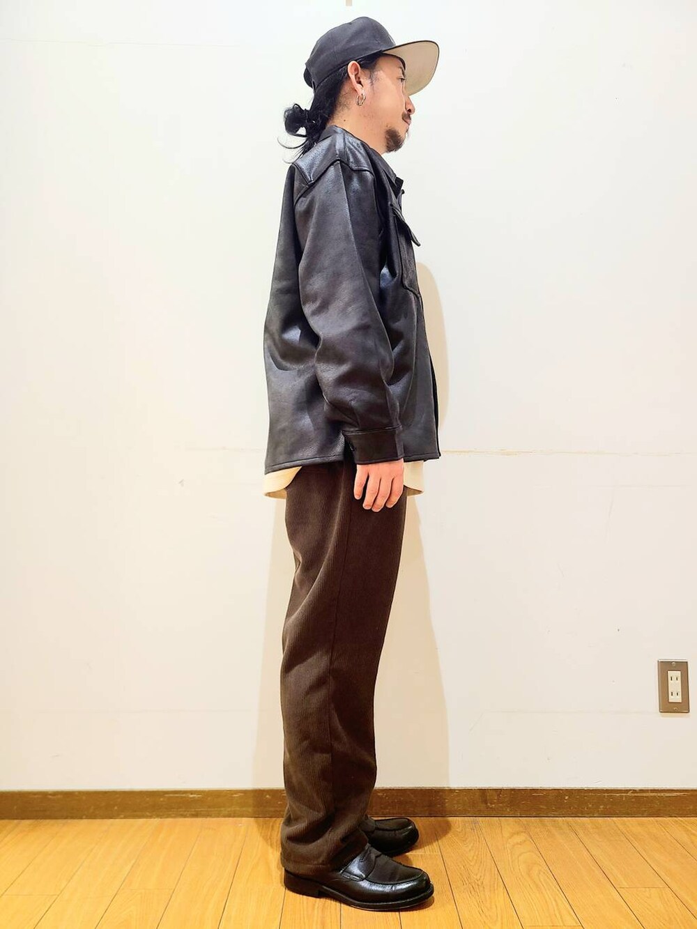 ブラック系のブルゾン、ブラウン系のその他パンツ、ホワイト系のTシャツ/カットソーを着用したメンズの冬コーディネートの2枚目の写真