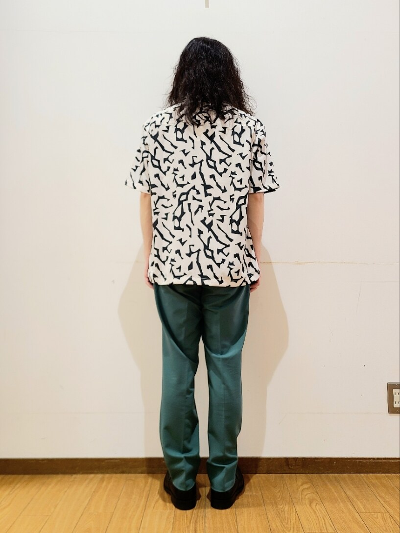 ホワイト系のシャツ/ブラウス、ブラック系のTシャツ/カットソー、グリーン系のスラックスを着用したメンズの春コーディネートの3枚目の写真