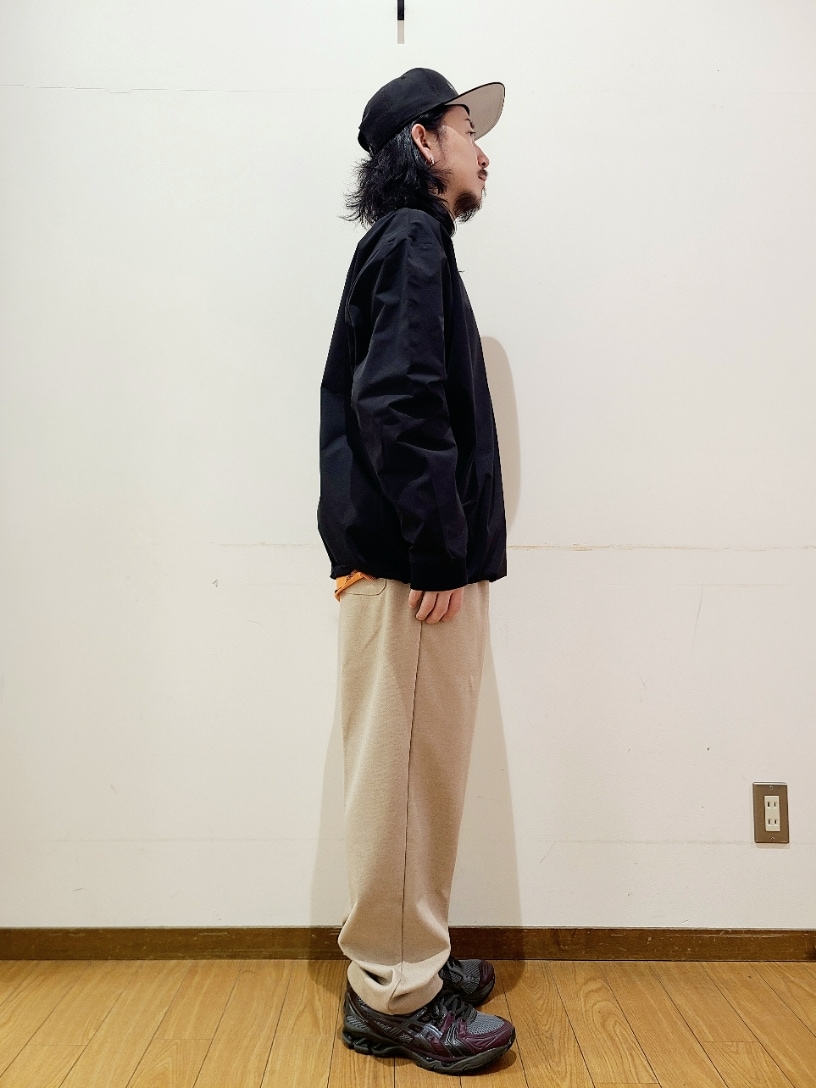 ブラック系のTシャツ/カットソー、オレンジ系のTシャツ/カットソー、ベージュ系のその他パンツを着用したメンズの冬コーディネートの2枚目の写真