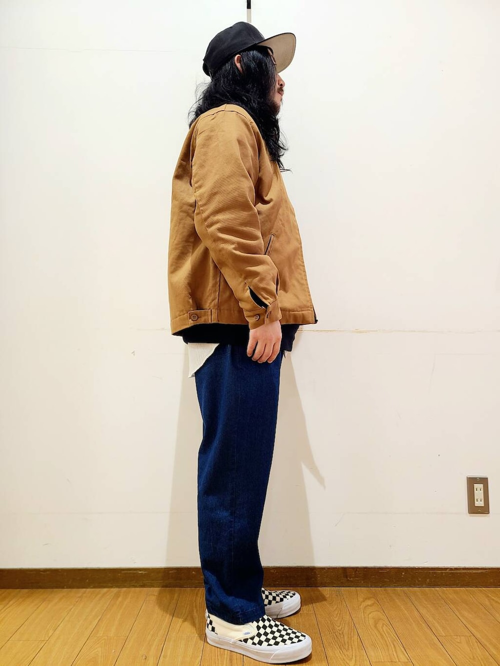 イエロー系のその他アウター、ブラック系のスニーカー、ブルー系のその他パンツを着用したメンズの冬コーディネートの2枚目の写真