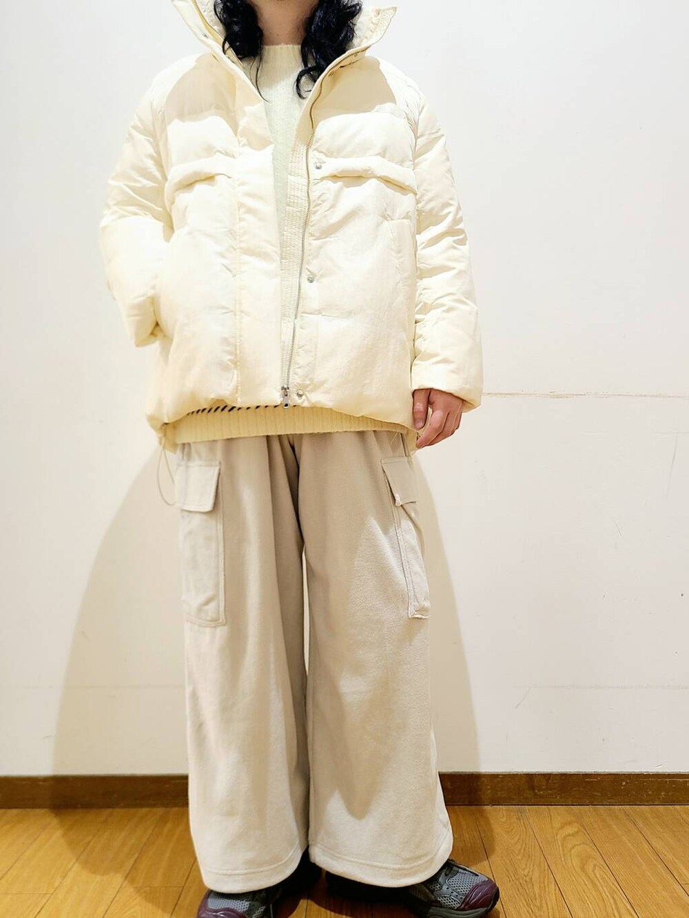 ホワイト系のダウンジャケット/コート、ホワイト系のニット/セーター、グレー系のその他パンツを着用したメンズの冬コーディネートの5枚目の写真