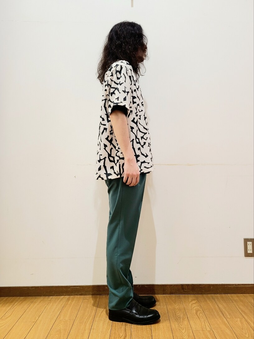 ホワイト系のシャツ/ブラウス、ブラック系のTシャツ/カットソー、グリーン系のスラックスを着用したメンズの春コーディネートの2枚目の写真