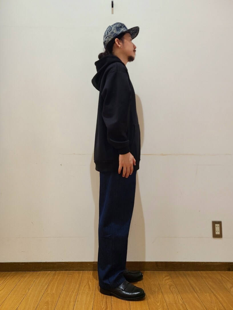 ブラック系のパーカー、ブルー系のデニムパンツを着用したメンズの秋コーディネートの2枚目の写真