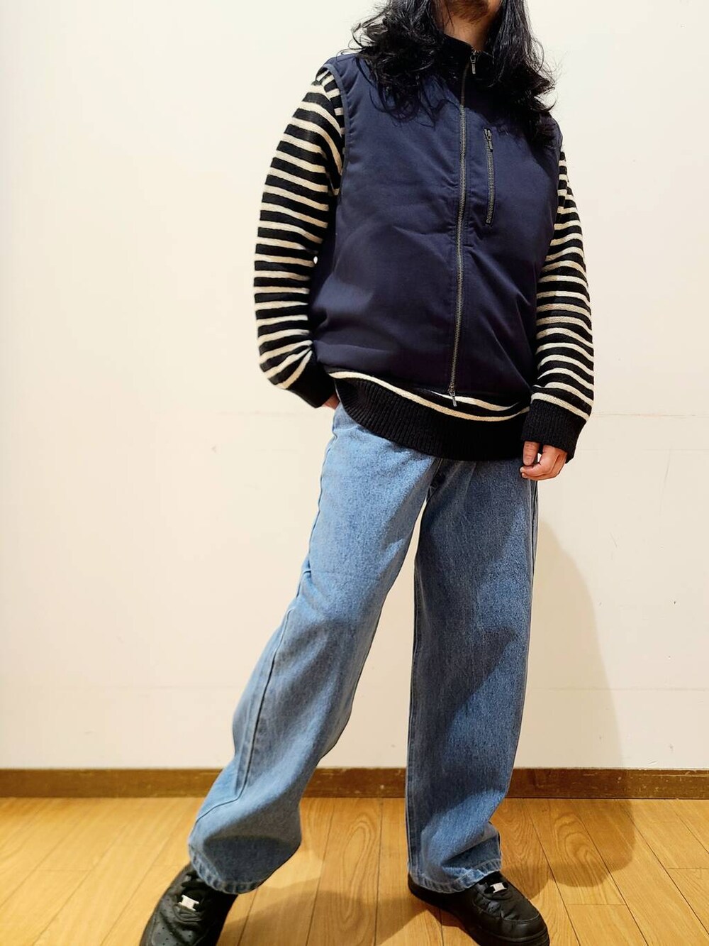 ブルー系のダウンベスト、ブルー系のデニムパンツ、ブラック系のニット/セーターを着用したメンズの冬コーディネートの5枚目の写真