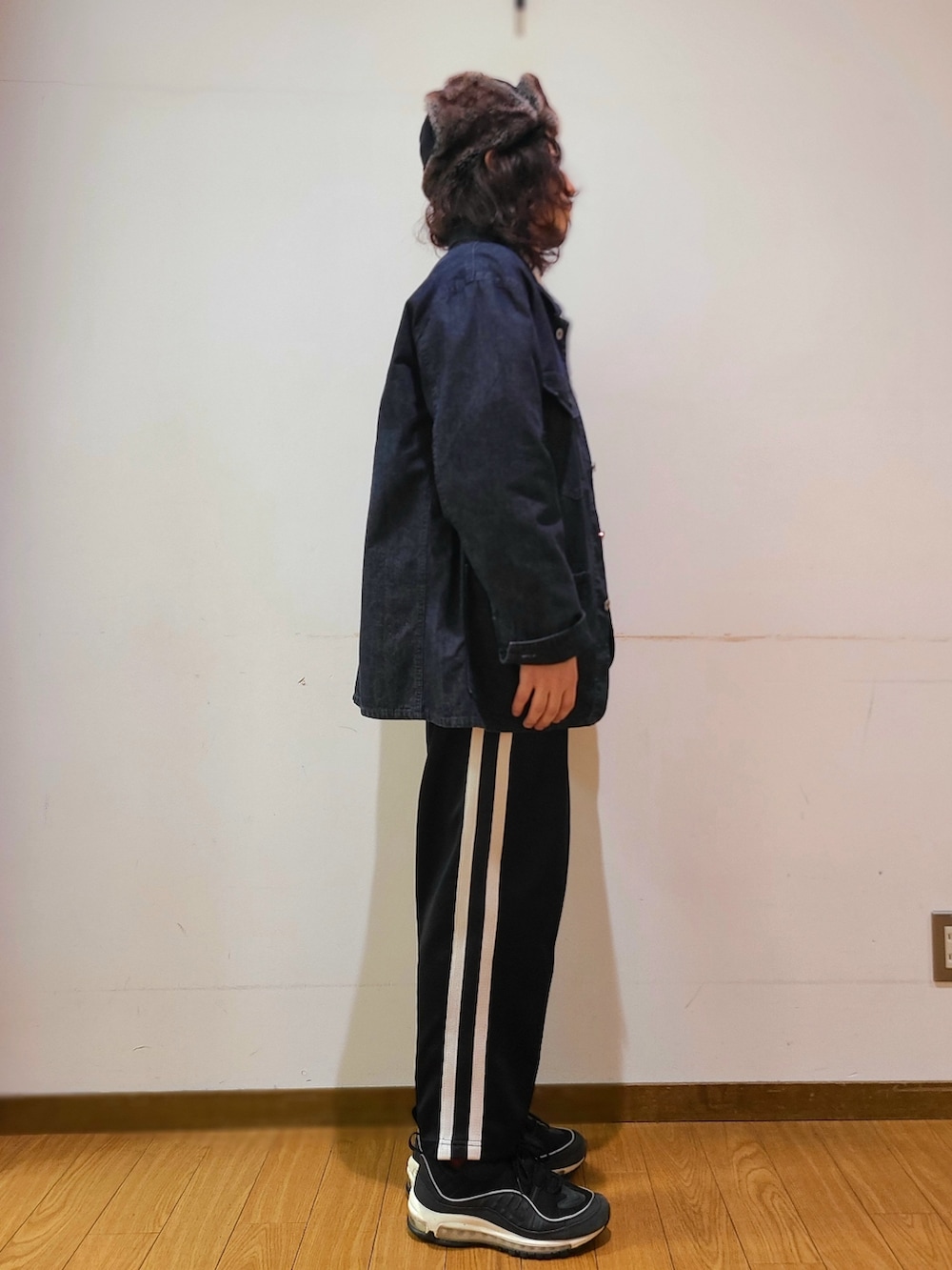 ブルー系のカバーオール、ブラック系のミリタリージャケット、ホワイト系のTシャツ/カットソーを着用したメンズの秋コーディネートの2枚目の写真