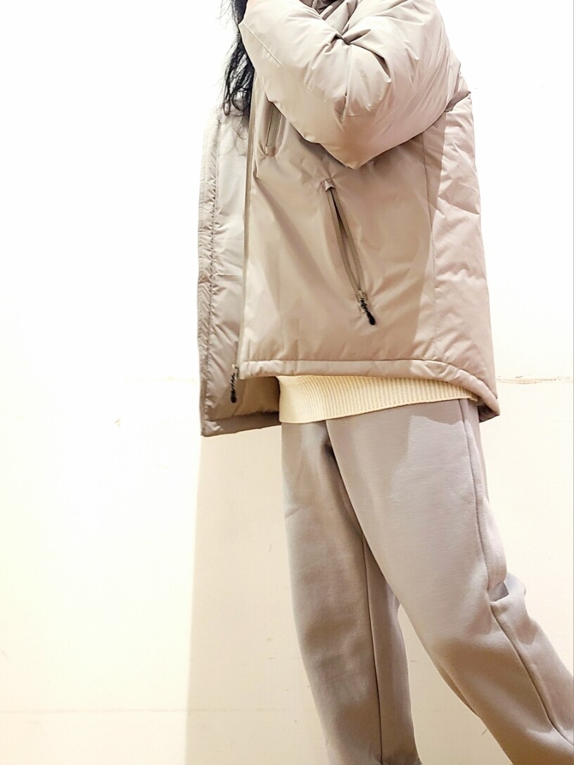 ホワイト系のニット/セーター、グレー系のスウェットパンツ、ベージュ系のダウンジャケット/コートを着用したメンズの冬コーディネートの7枚目の写真