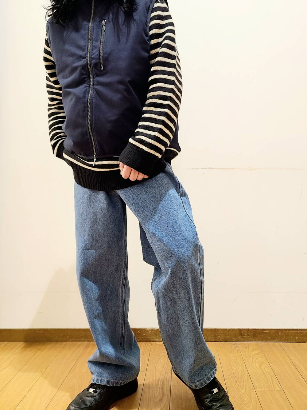 ブルー系のダウンベスト、ブルー系のデニムパンツ、ブラック系のニット/セーターを着用したメンズの冬コーディネートの4枚目の写真