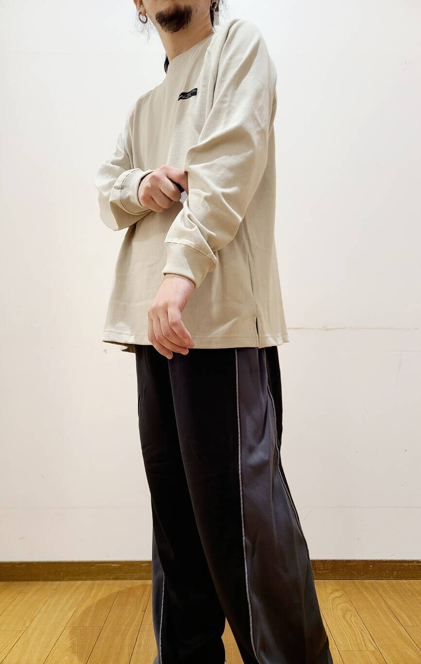 ベージュ系のTシャツ/カットソー、ブラック系のその他パンツを着用したメンズの秋コーディネートの6枚目の写真