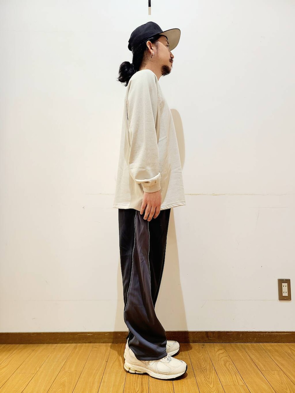 ベージュ系のTシャツ/カットソー、ブラック系のその他パンツを着用したメンズの秋コーディネートの2枚目の写真