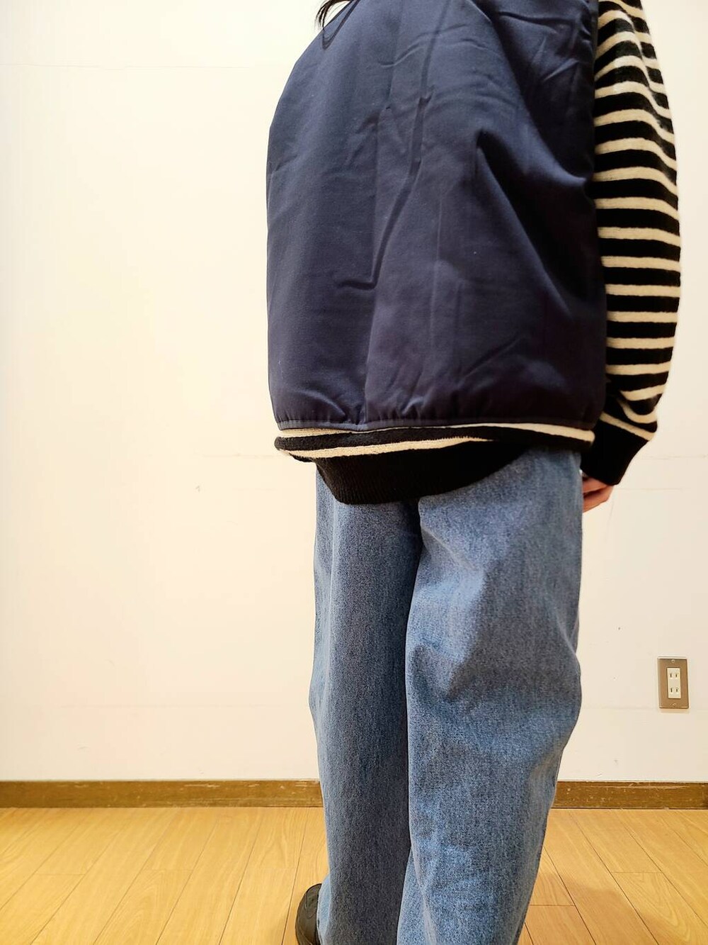 ブルー系のダウンベスト、ブルー系のデニムパンツ、ブラック系のニット/セーターを着用したメンズの冬コーディネートの9枚目の写真